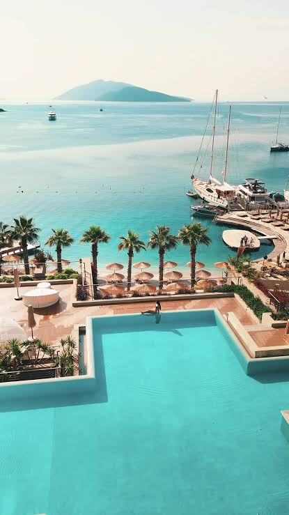 Pools, palms and terraces overlooking the turquoise Aegean bay at Caresse