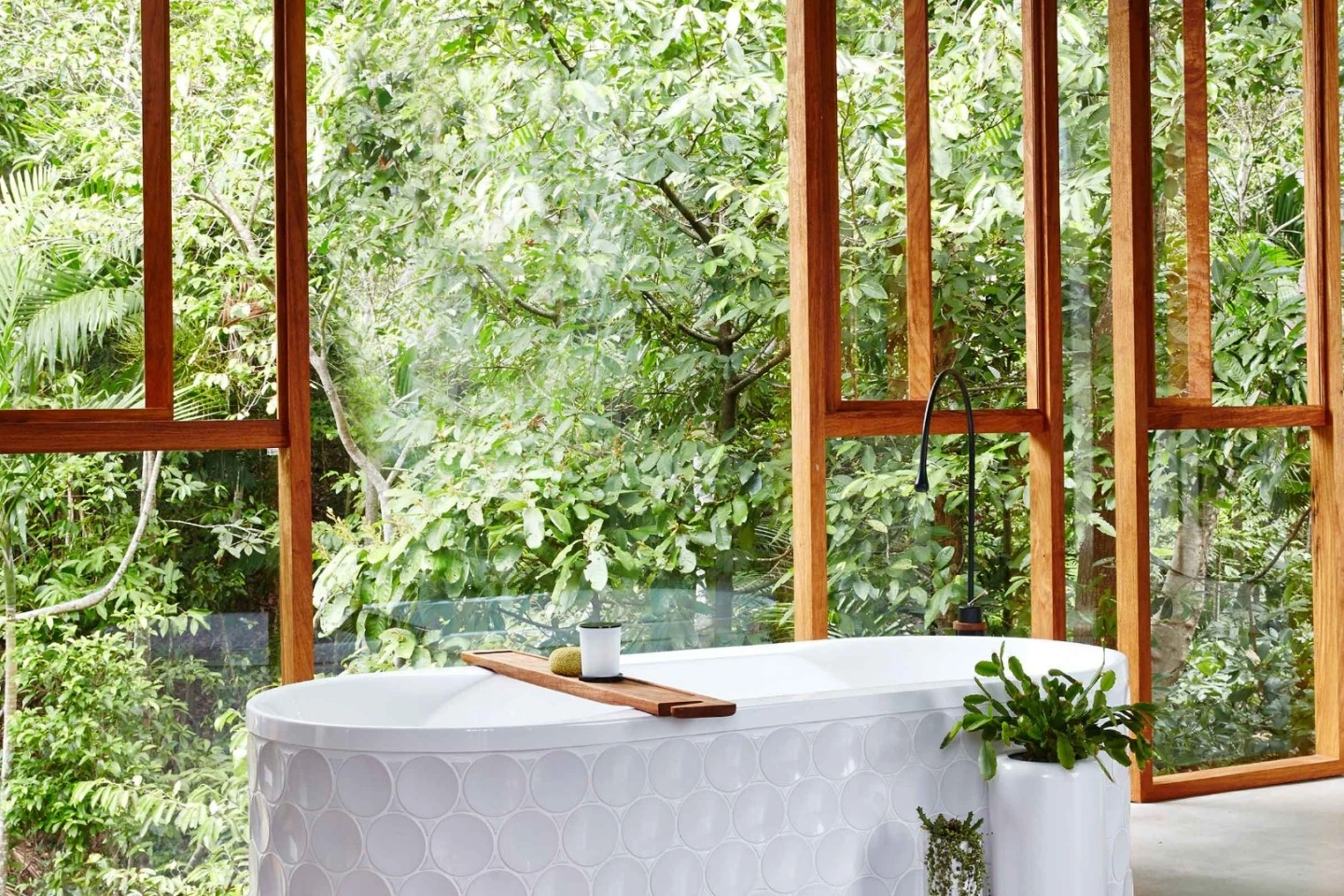 Dot tiled bath framed by the open rainforest windows