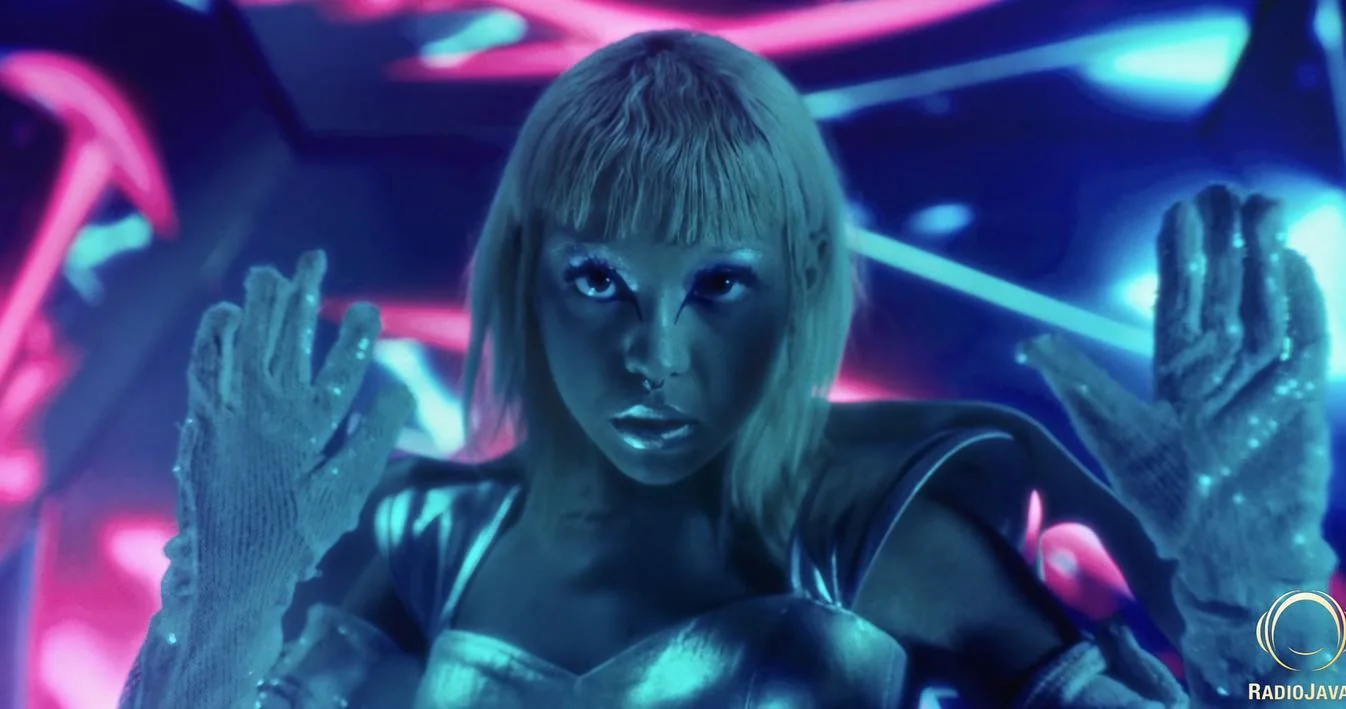 A performer and colourful reflections in the Hooman music video