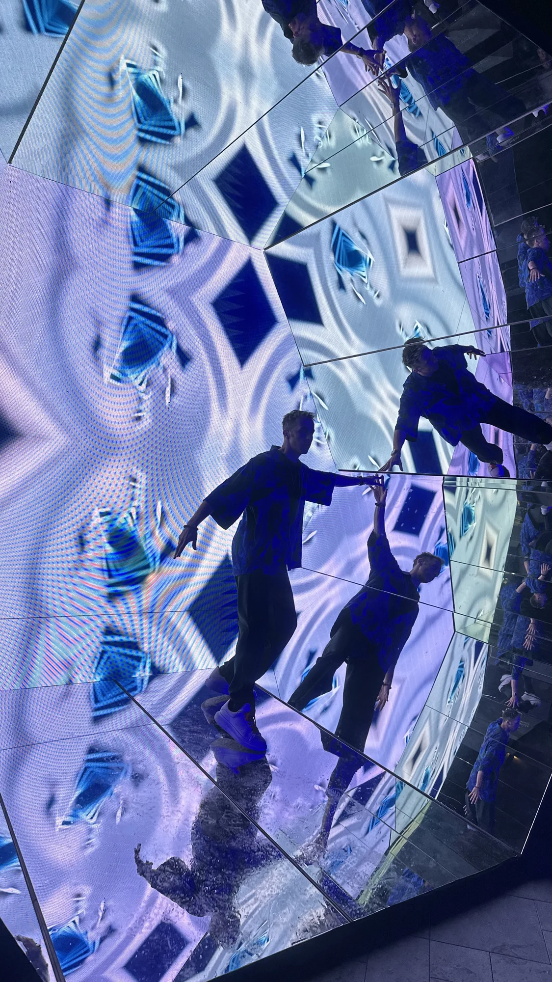 A visitor multiplied through the mirrored geometry at the Red Bull event