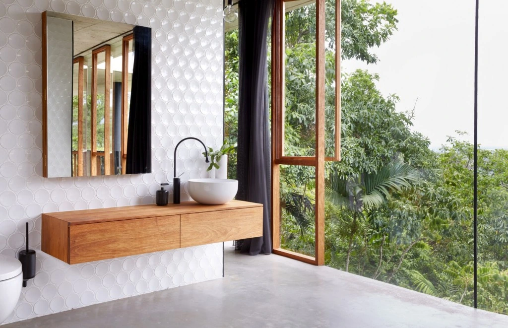Wide bathroom view with timber vanity and tropical forest